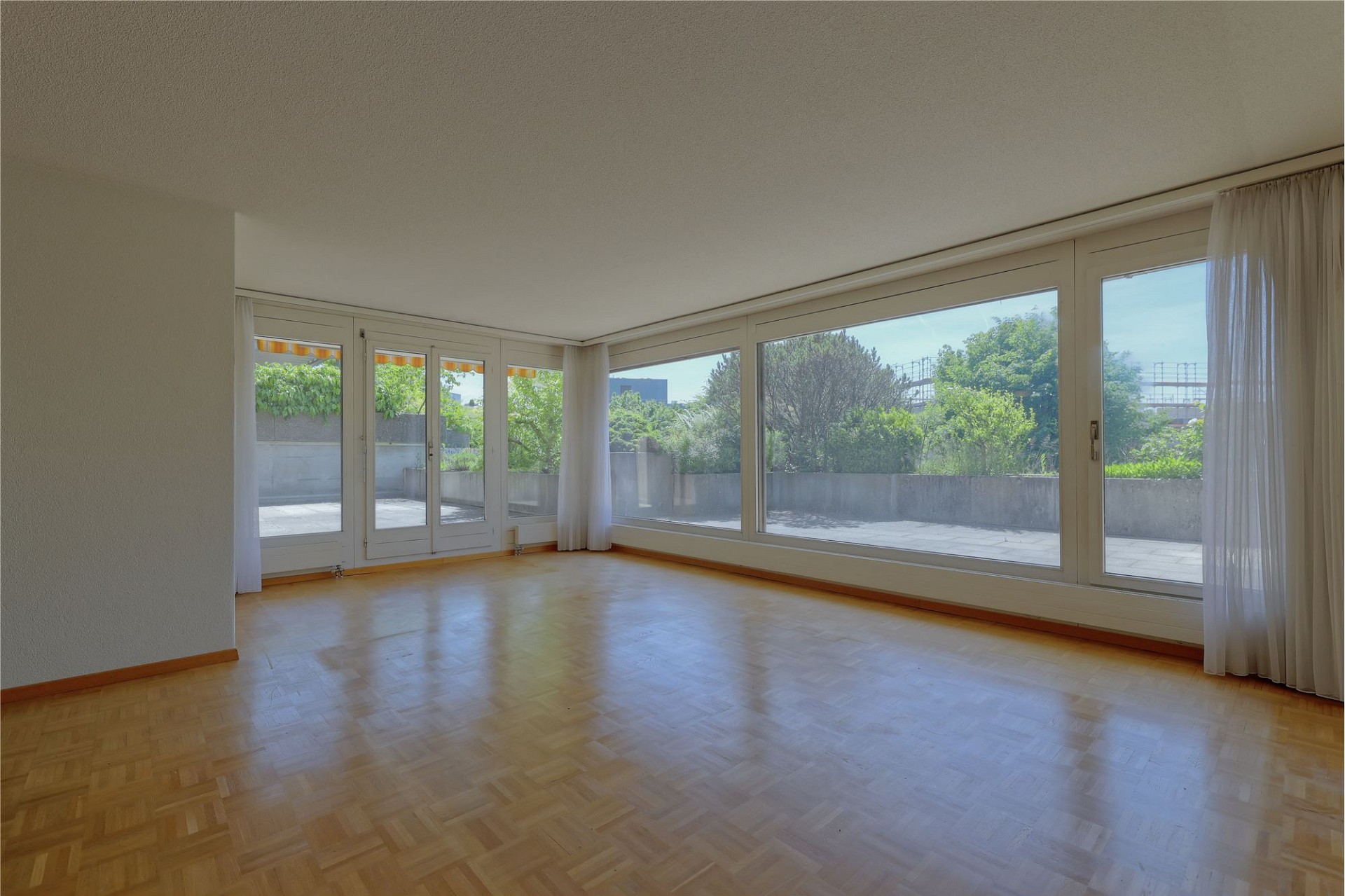 Helles, leeres Wohnzimmer mit Panoramafenstern