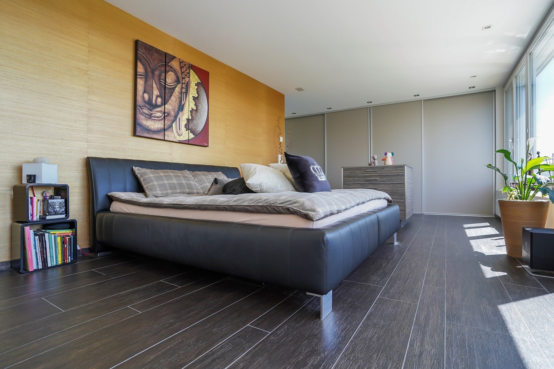 Modernes Schlafzimmer mit dunklem Boden und großen Fenstern