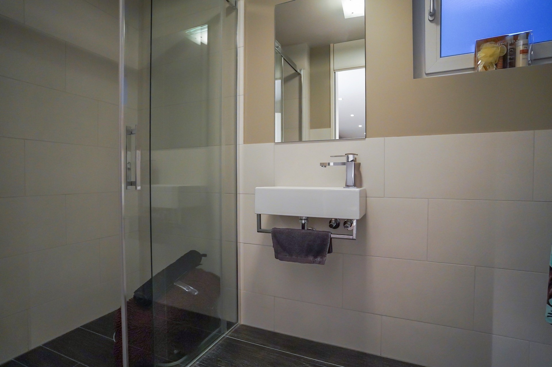 Modernes Badezimmer mit Glasdusche und Wandwaschbecken