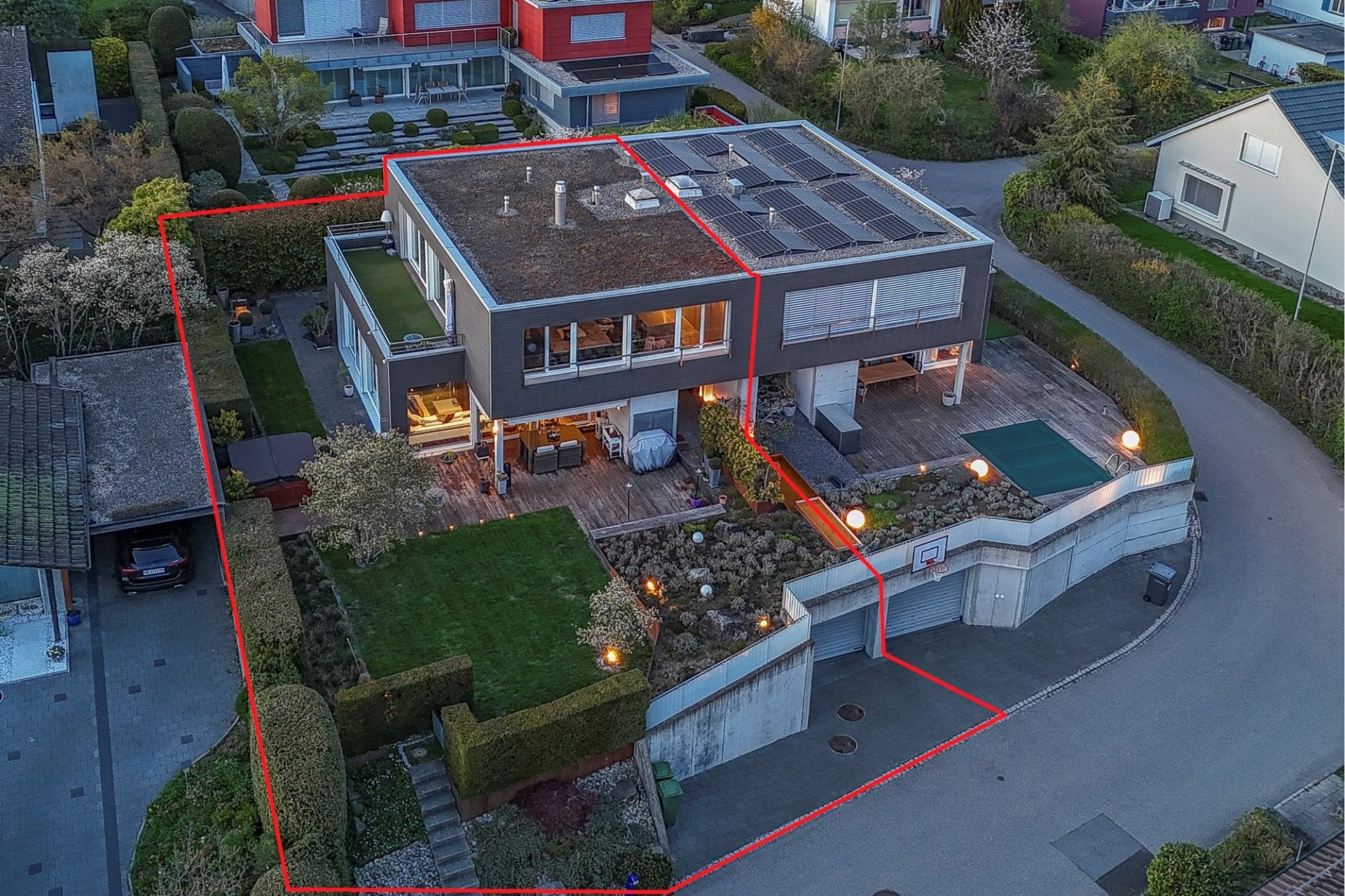 Drohnenaufnahme eines modernen Einfamilienhauses mit Garten und Dachterrasse