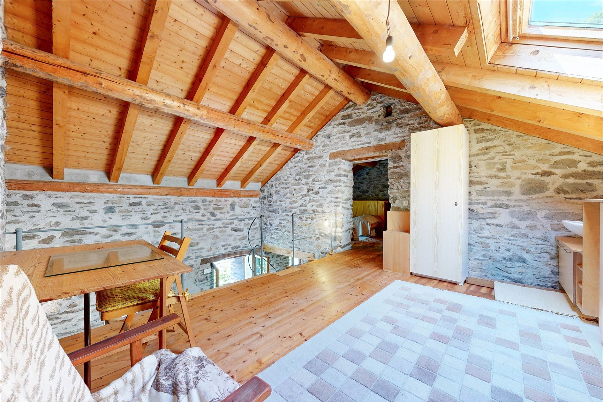 Ausgebauter Dachraum mit Naturstein und Holzbalken