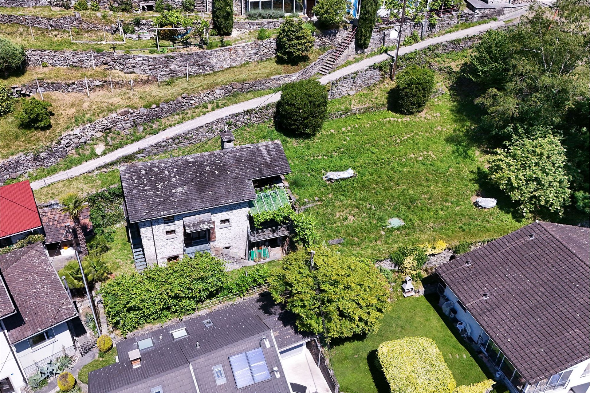 Luftaufnahme eines Wohnhauses mit Garten und Hanglage