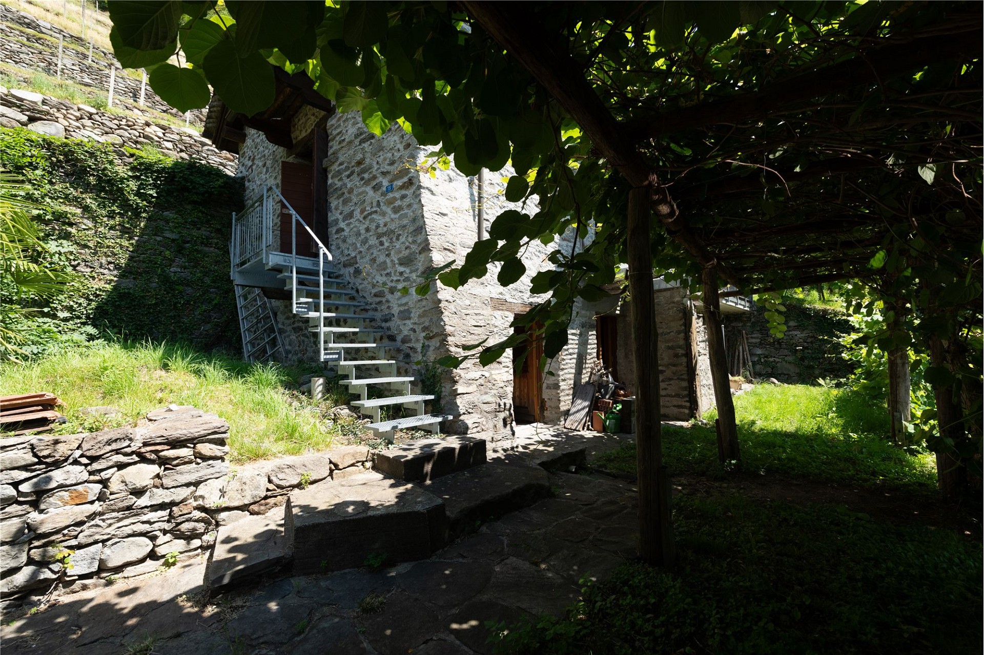 Steinhaus mit Außentreppe im Garten