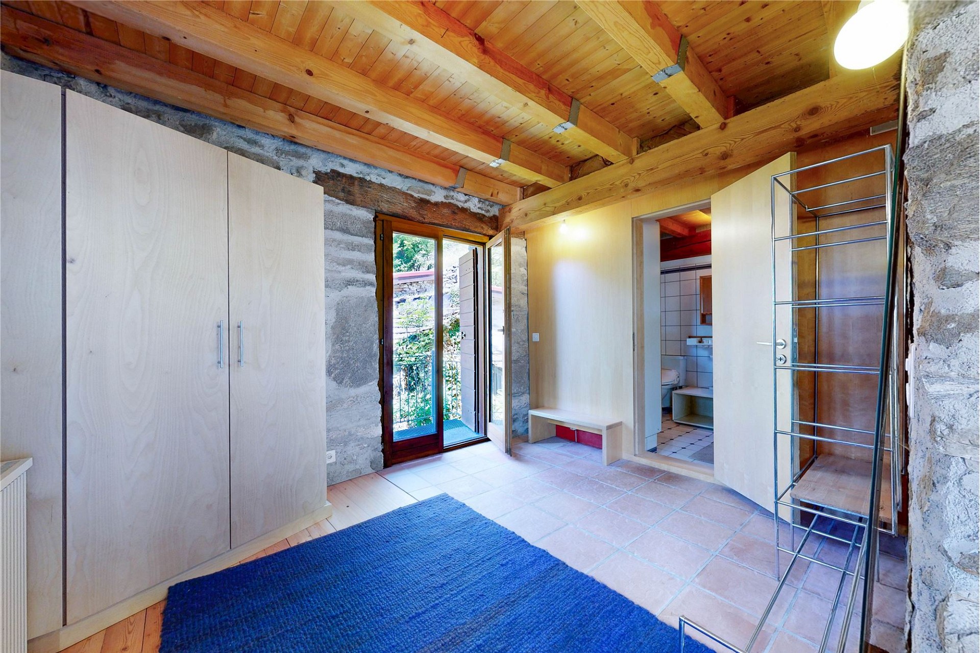 Rustikaler Innenraum mit sichtbaren Holzbalken und Naturstein