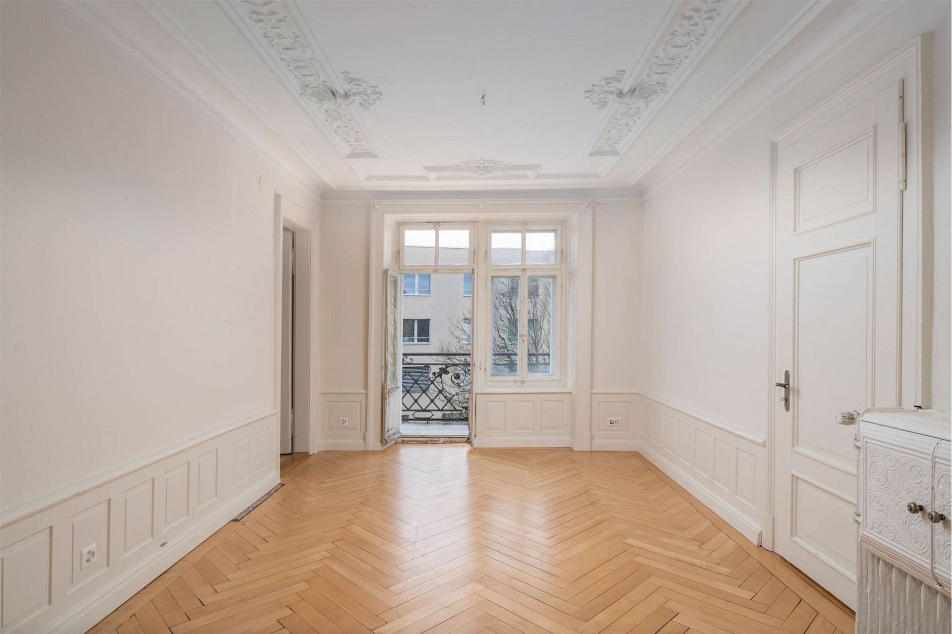 Heller Altbau-Raum mit Parkett und Stuckdecke