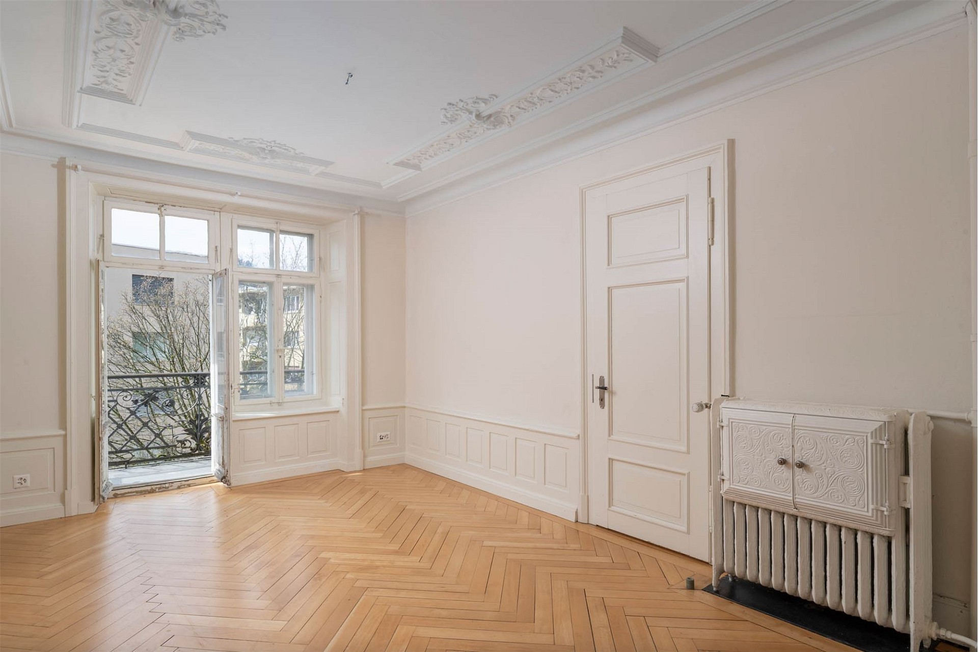 Heller Altbau-Raum mit Parkett und Balkontür
