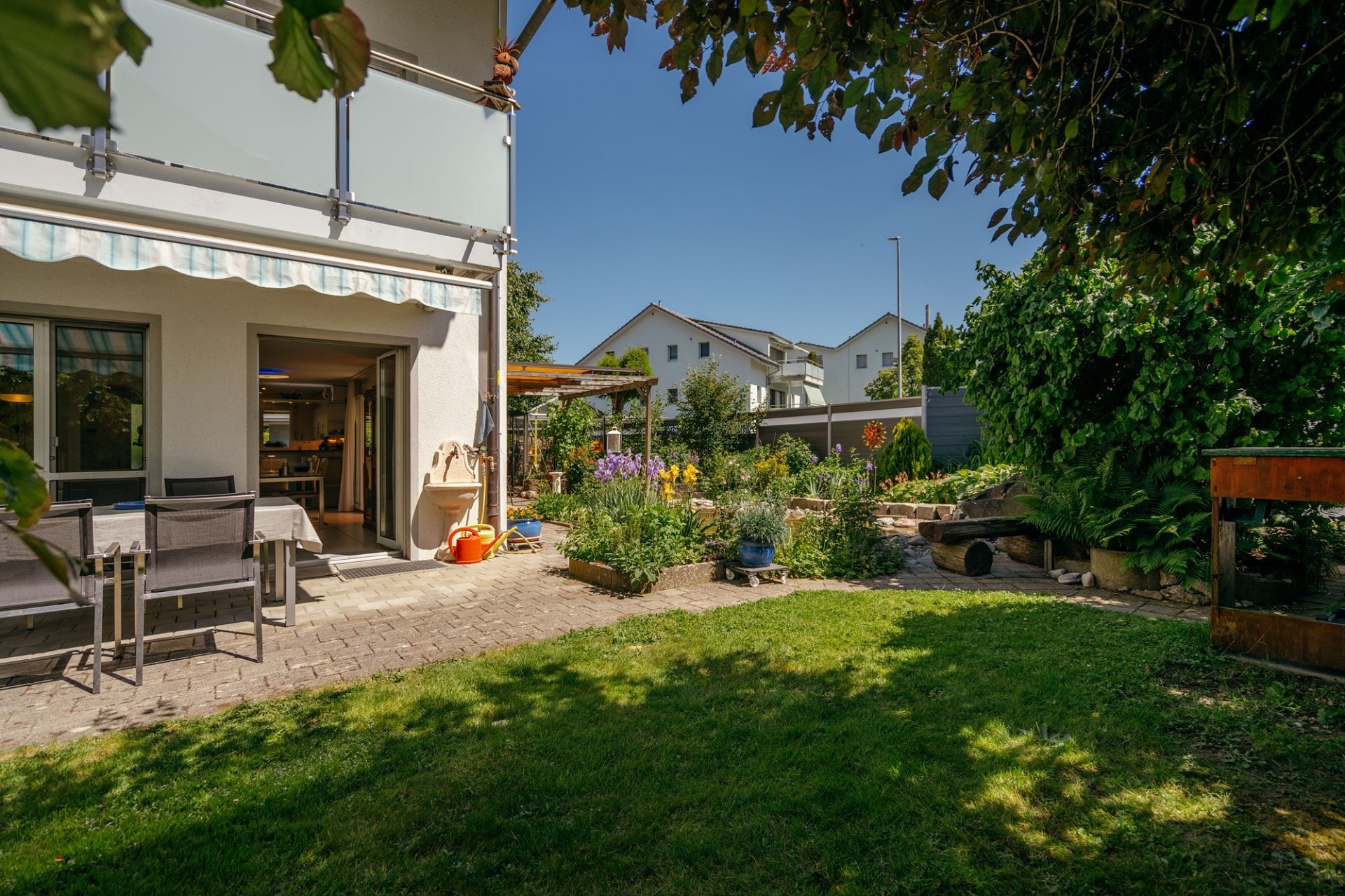 Garten mit Terrasse und Hausansicht