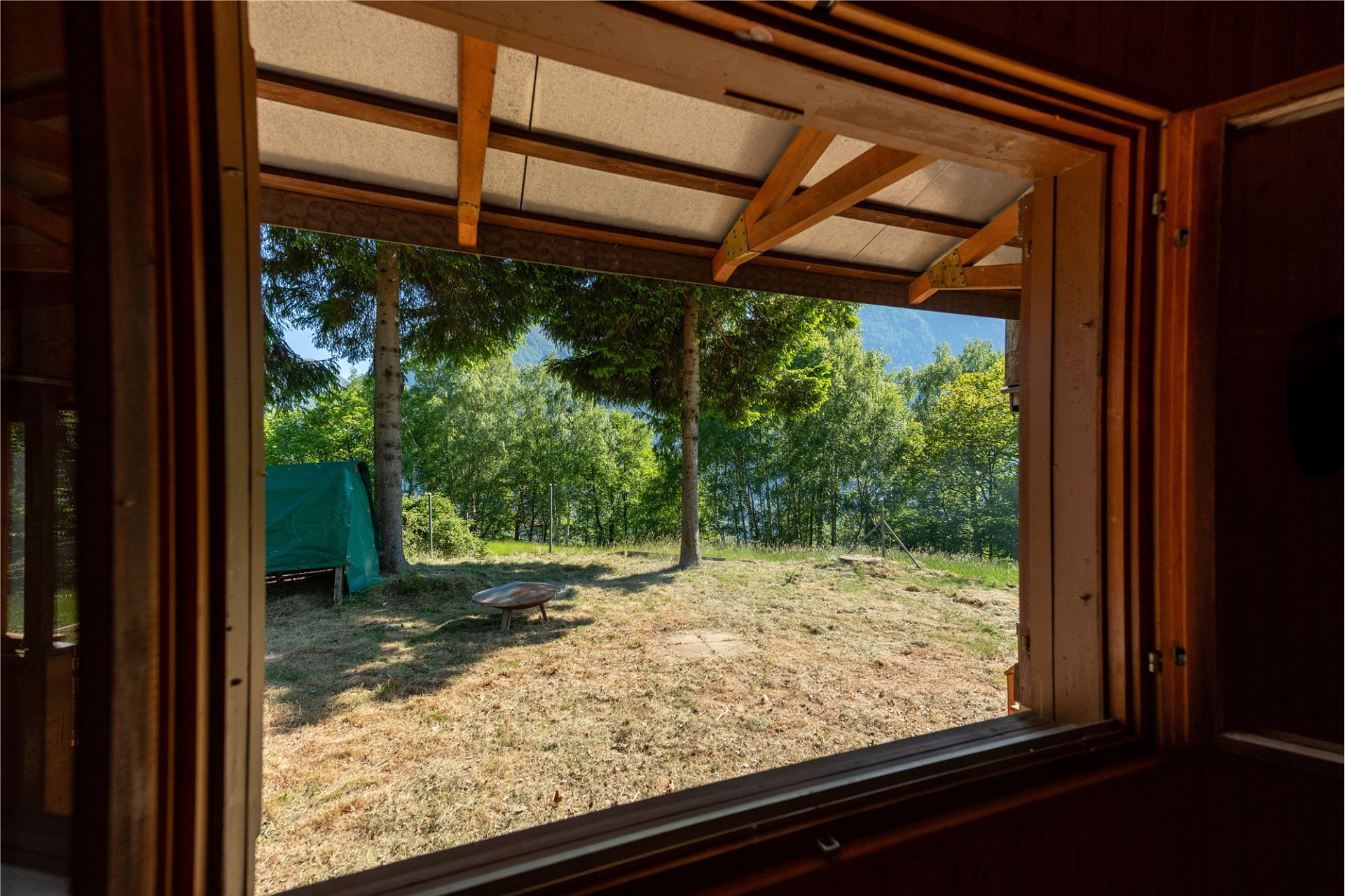 Blick auf eine Terrasse/überdachte Öffnung ins Grüne