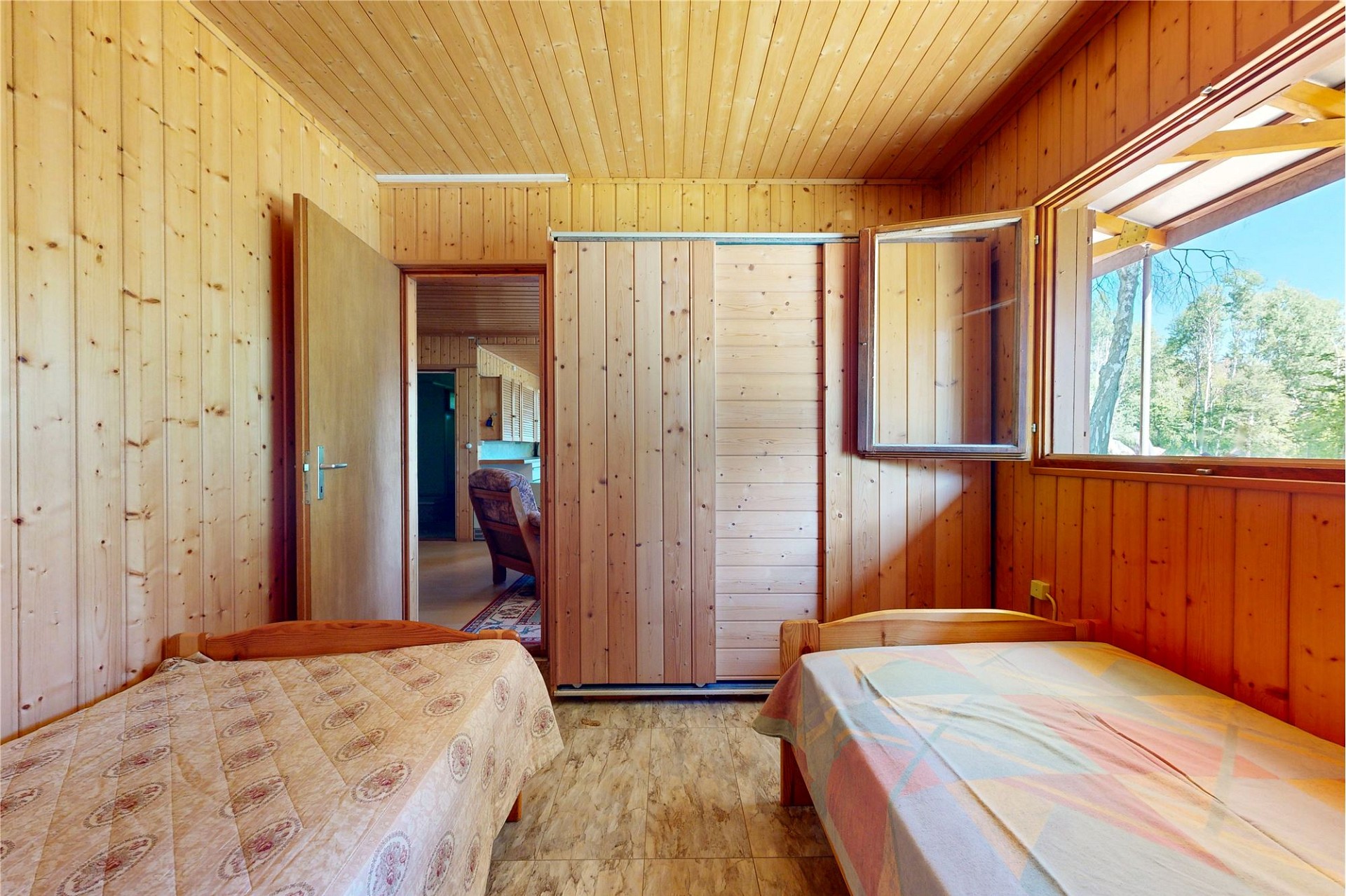 Holzverkleidetes Schlafzimmer mit zwei Einzelbetten