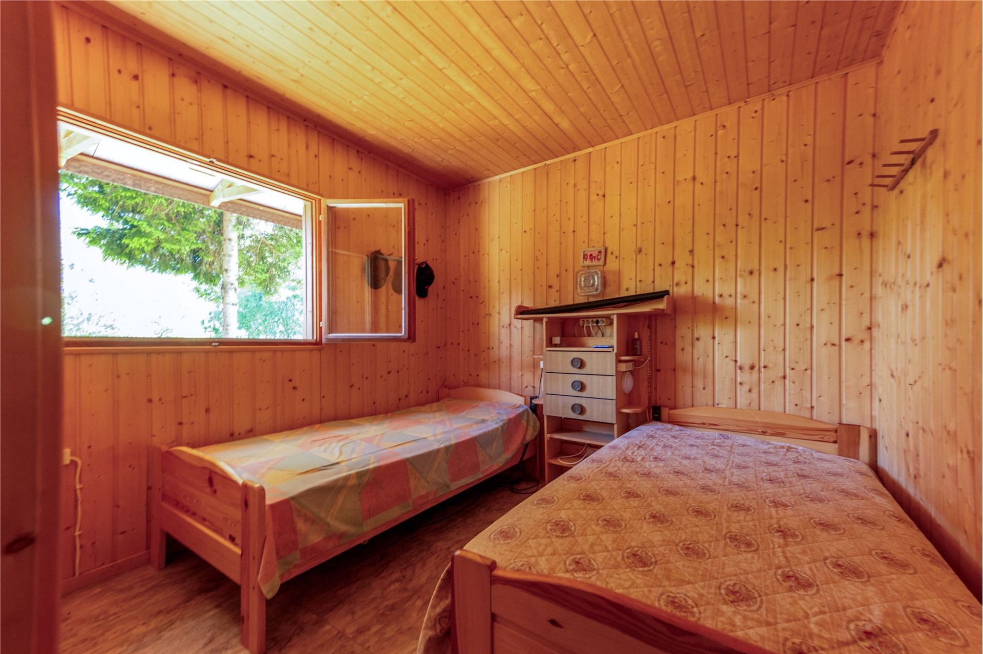 Holzverkleidetes Schlafzimmer mit zwei Betten