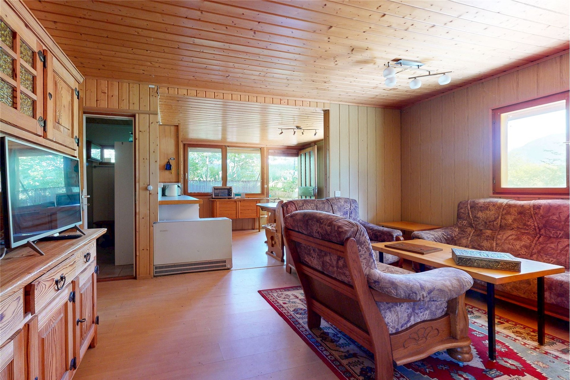 Gemütliches Holz-Wohnzimmer mit Durchgang zum Nebenraum