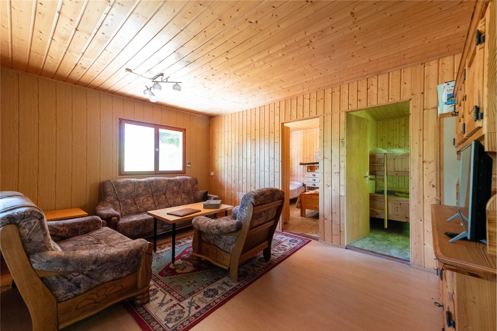 Gemütliches Holz-Wohnzimmer mit Schlafbereich