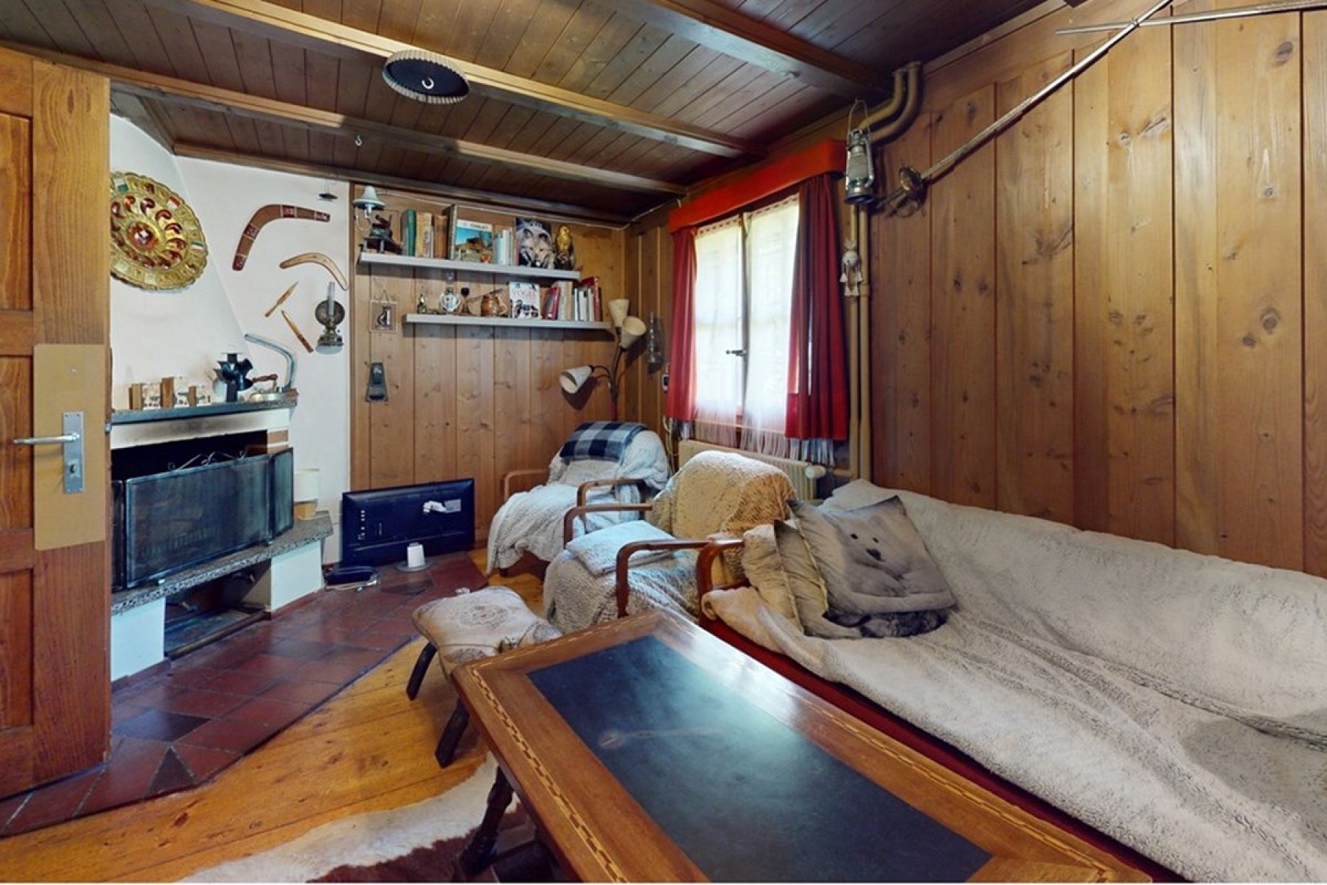 Gemütliches, rustikales Wohnzimmer mit Kamin und Holzverkleidung