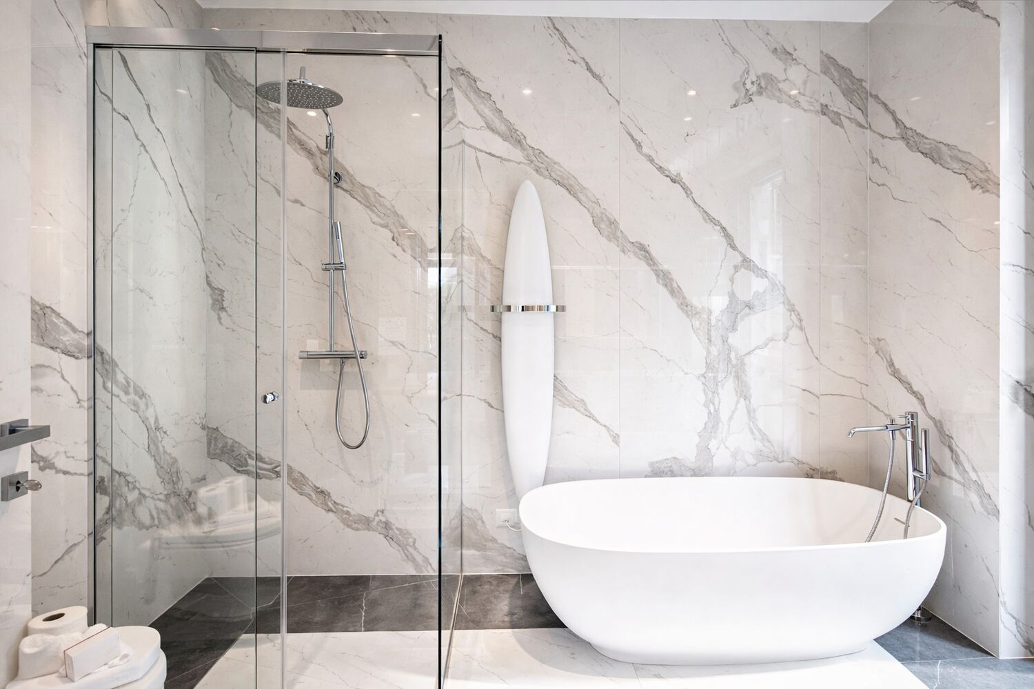 Luxuriöses Badezimmer mit freistehender Wanne und Marmordusche