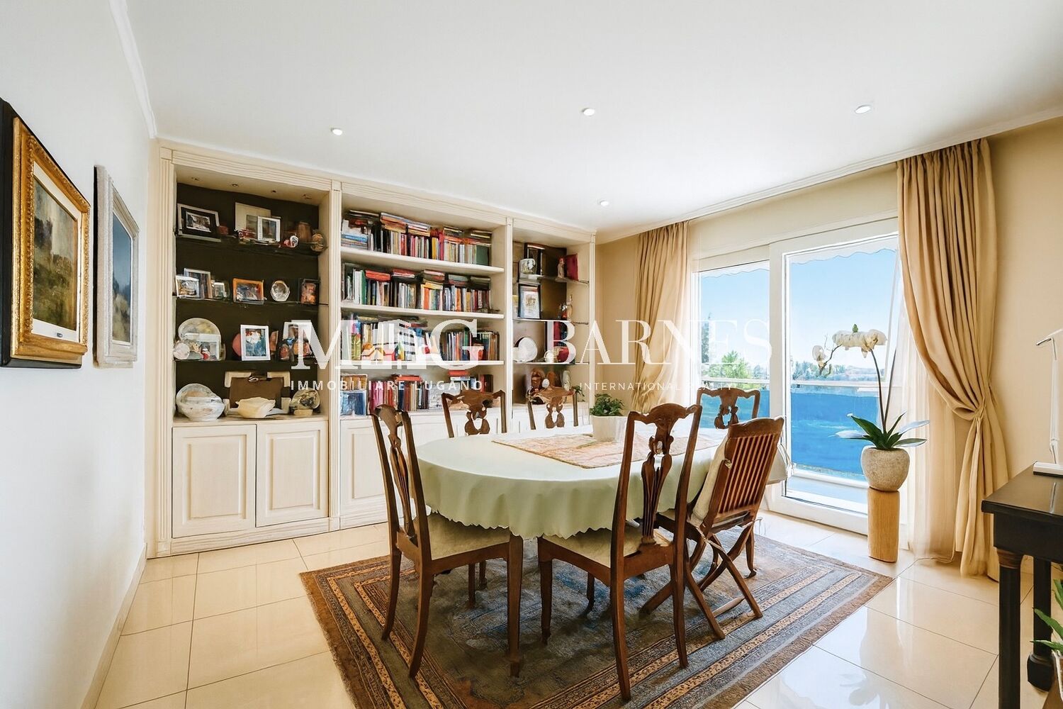 Helles Esszimmer mit Bücherregalen und Balkonblick