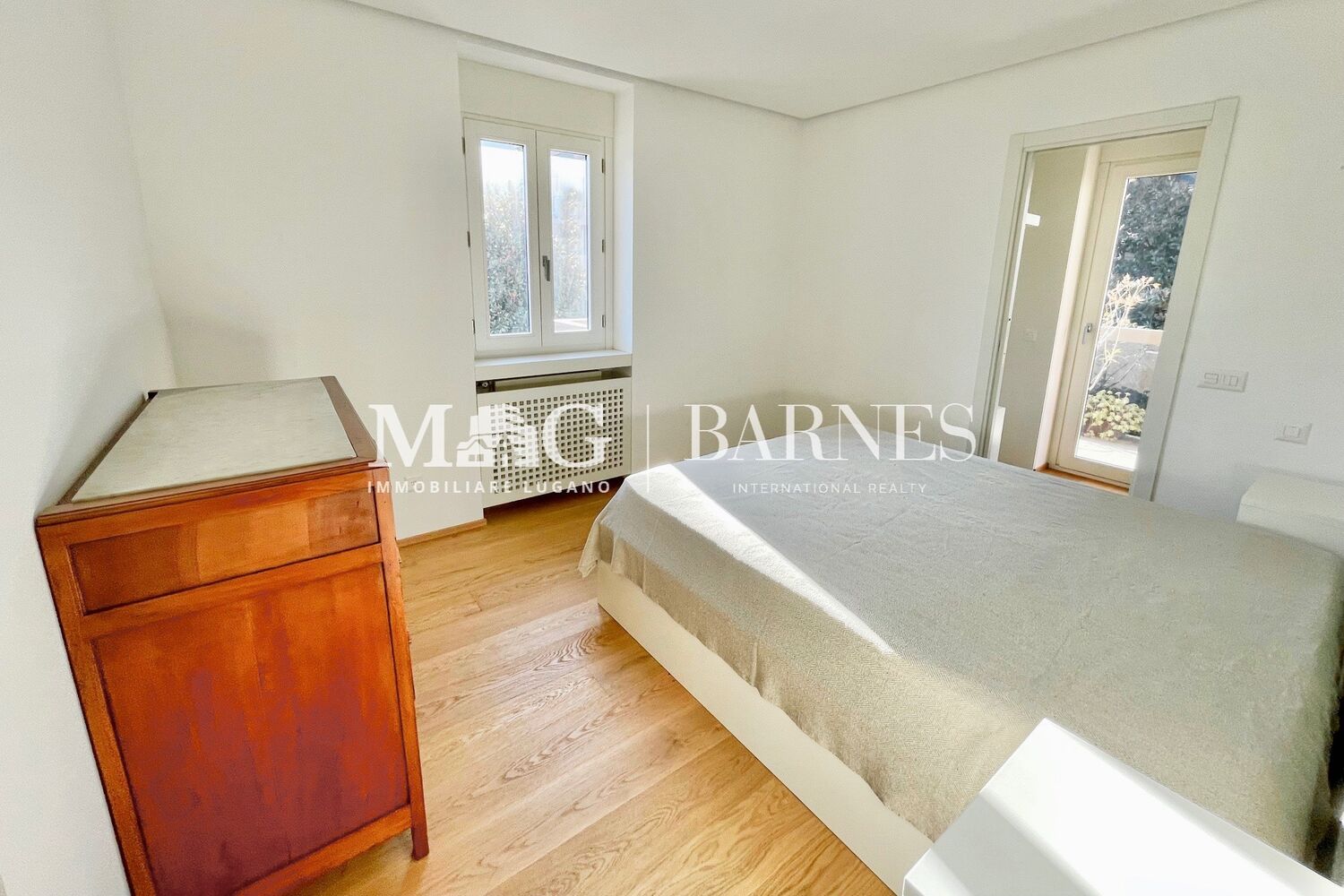 Helles Schlafzimmer mit Holzparkett und Balkonzugang