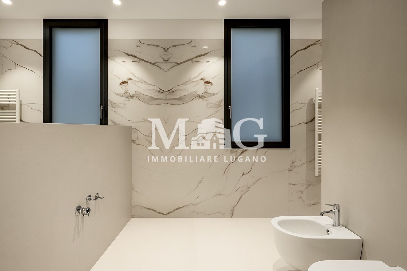 Modernes Badezimmer mit Marmoroptik und Oberlichtfenstern