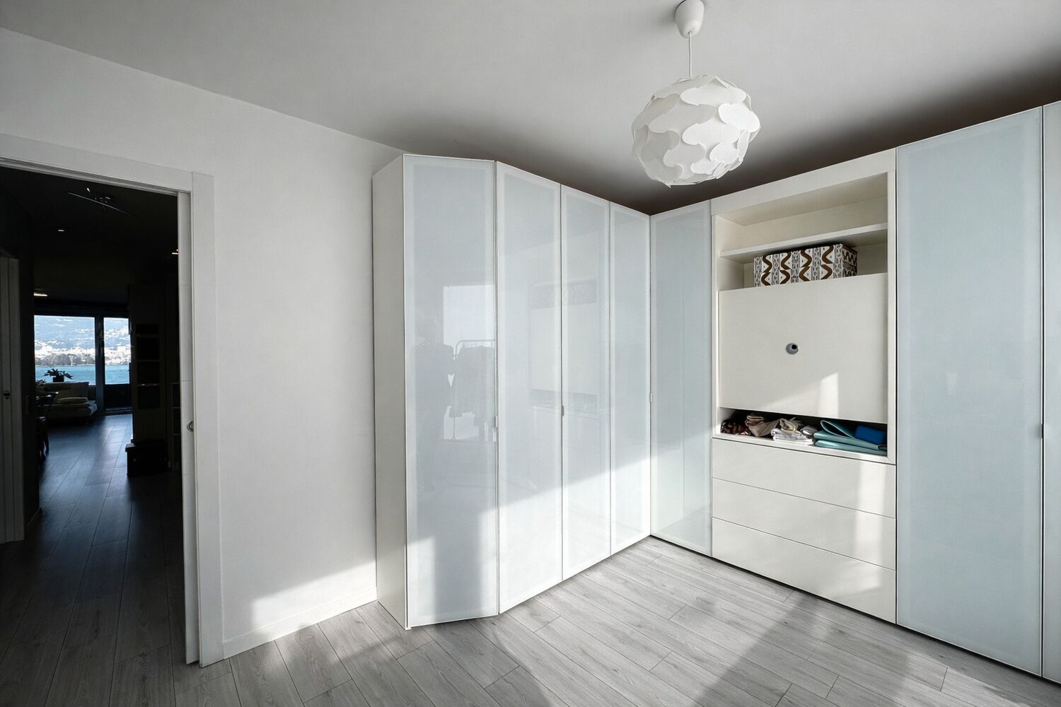Helles Schlafzimmer mit Einbauschränken und Ausblick aufs Wasser