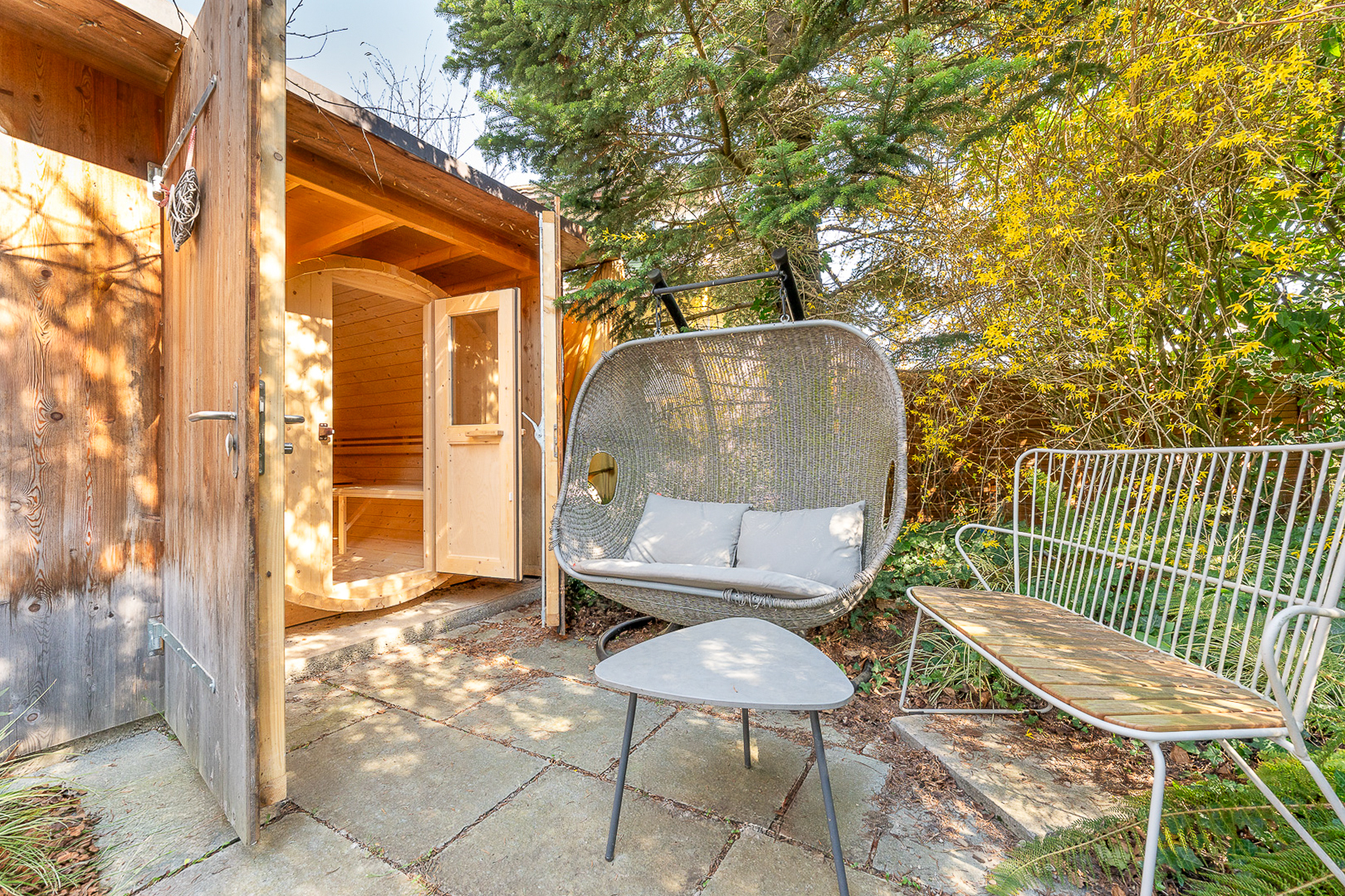 Gartenbereich mit kleiner Holzsauna und Sitzgruppe