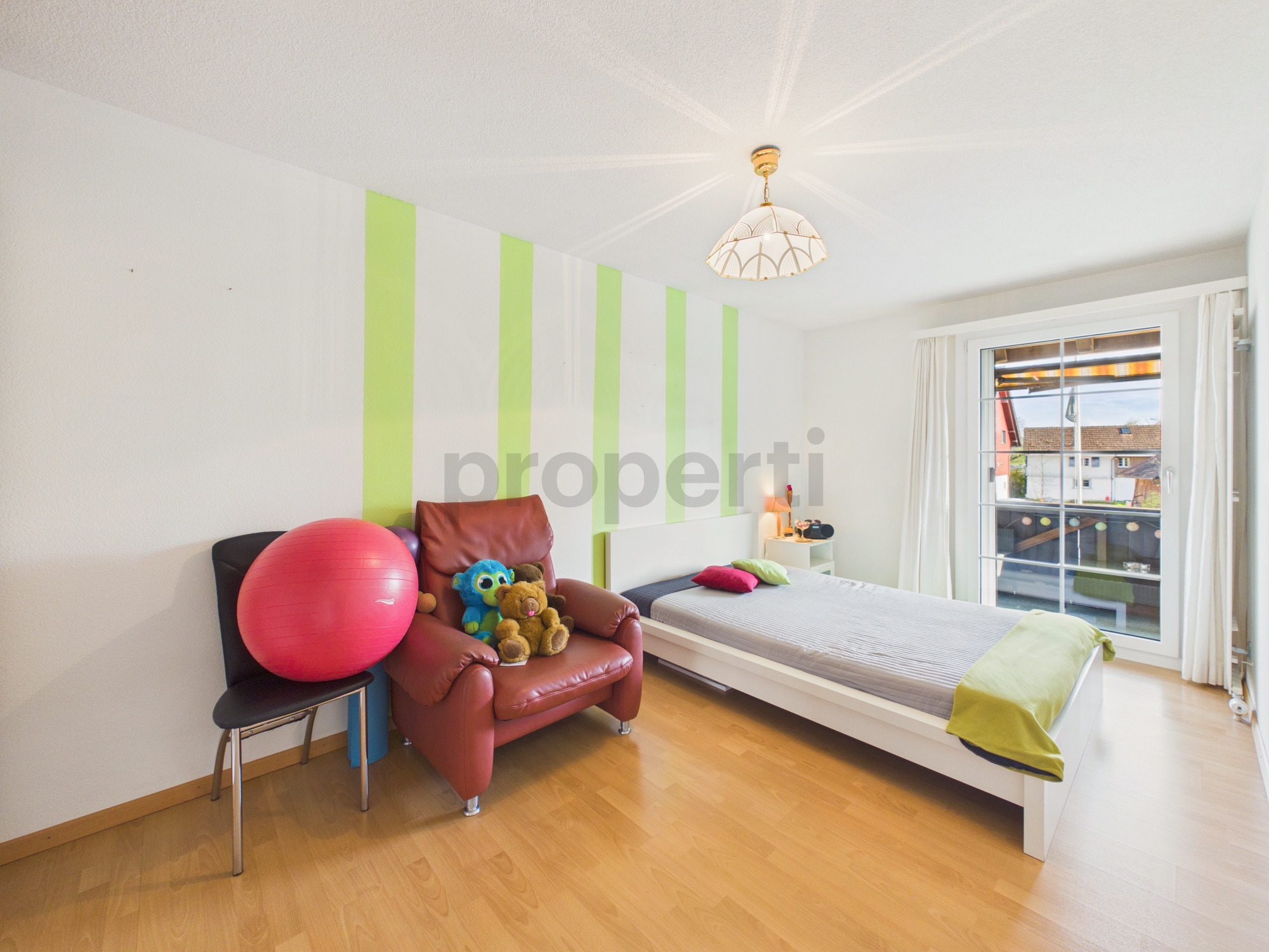 Helles Kinderzimmer mit Einzelbett und Sitzbereich