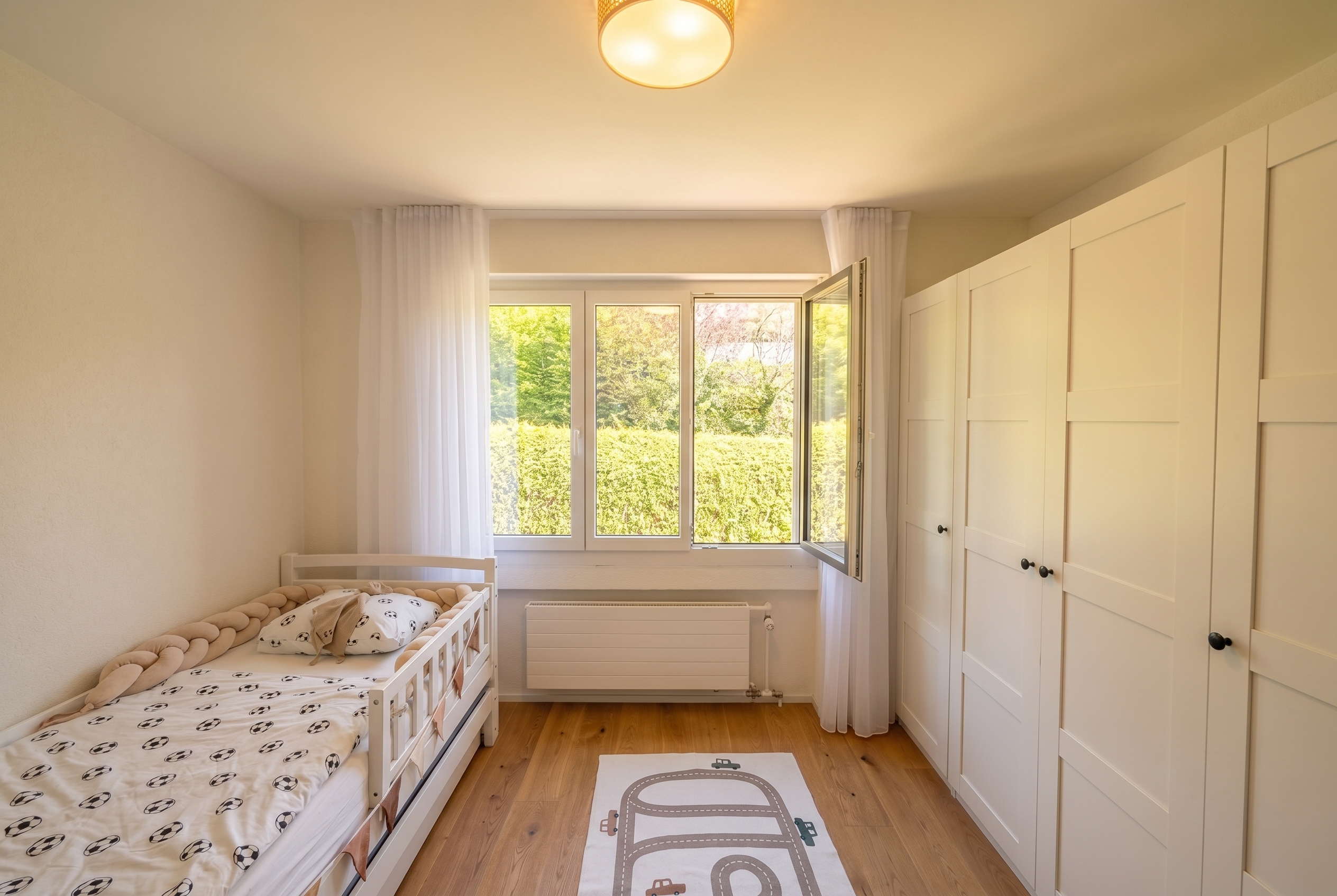 Helles Kinderzimmer mit Fensterfront und Einbauschrank