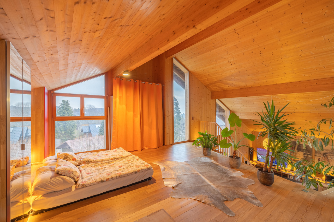 Ausgebauter Schlafbereich mit Holzverkleidung und großen Fenstern