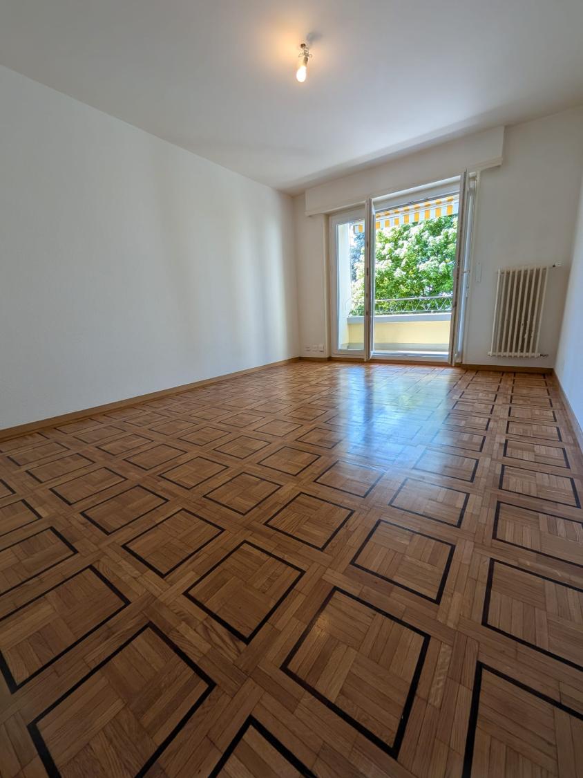 Heller Raum mit Parkett und Balkon