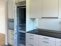 Moderne Einbauküche mit Kühl-/Gefrierschrank und Hochschrankfronten