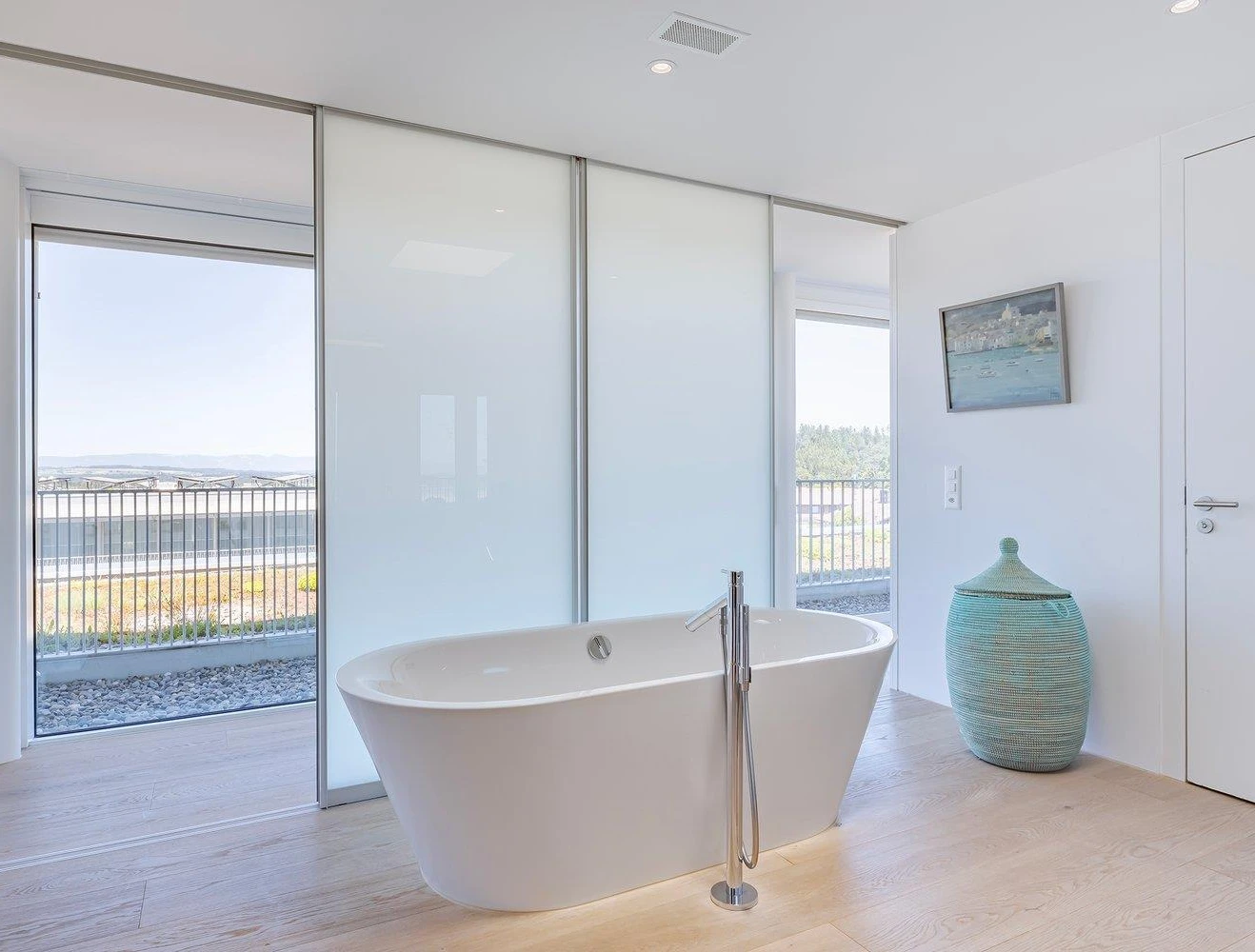 Modernes Badezimmer mit freistehender Badewanne und Balkonblick