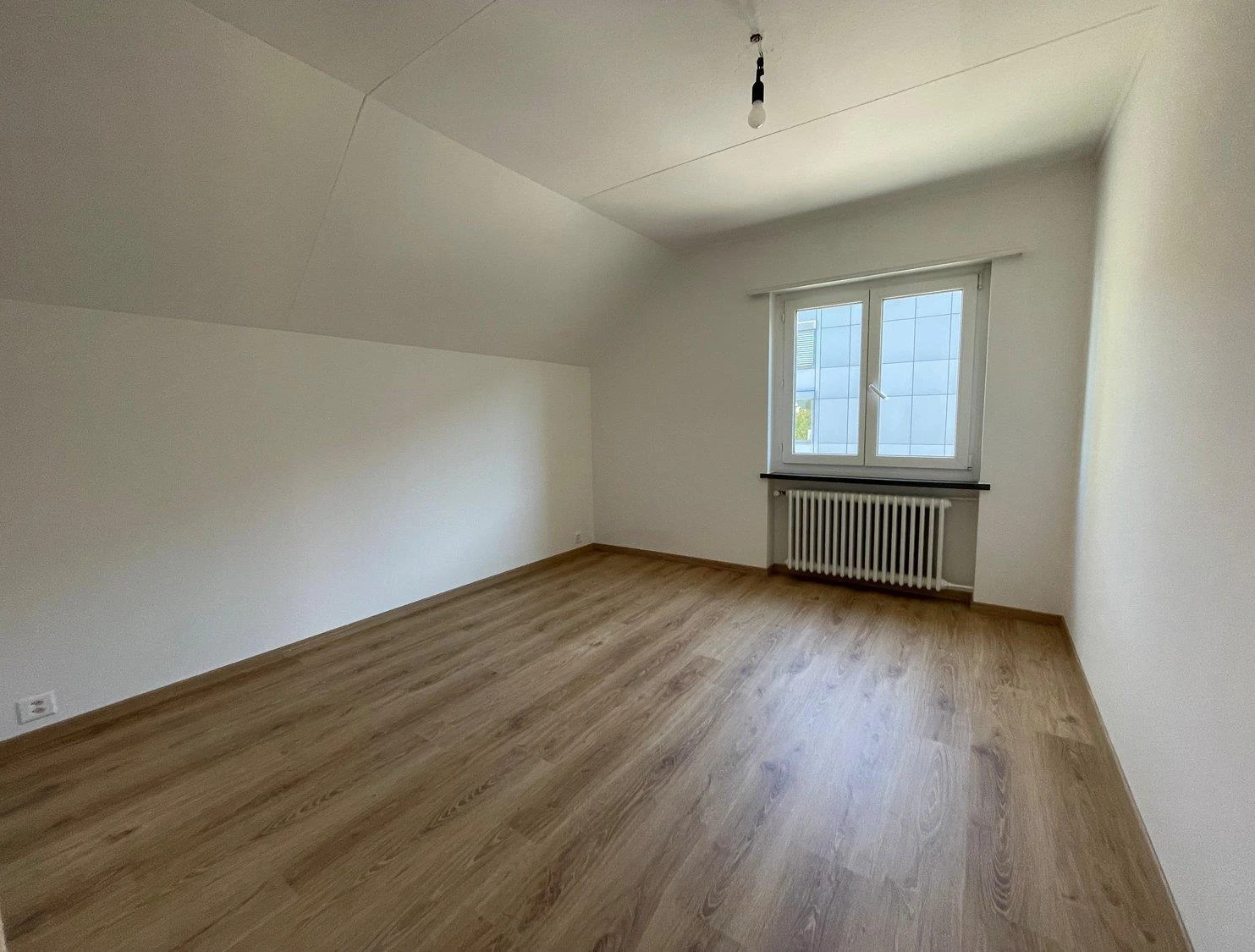 Leerer Dachraum mit Holzoptikboden