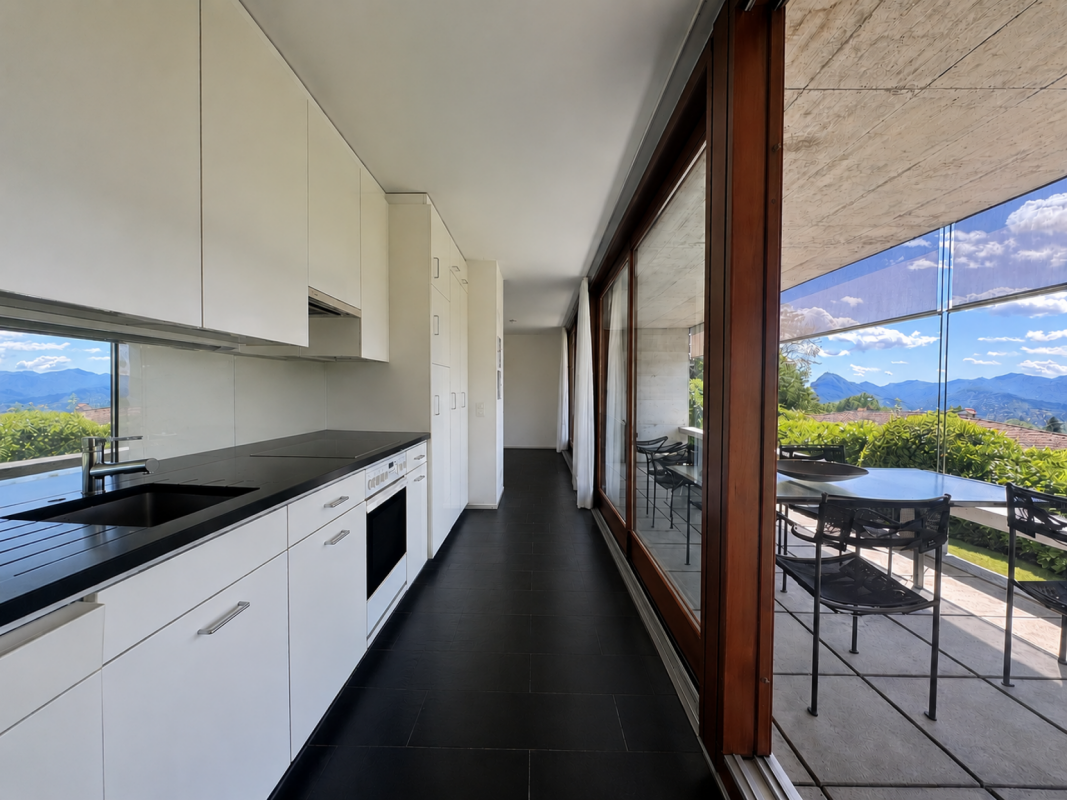 Moderne Küche mit großflächiger Verglasung und Bergblick
