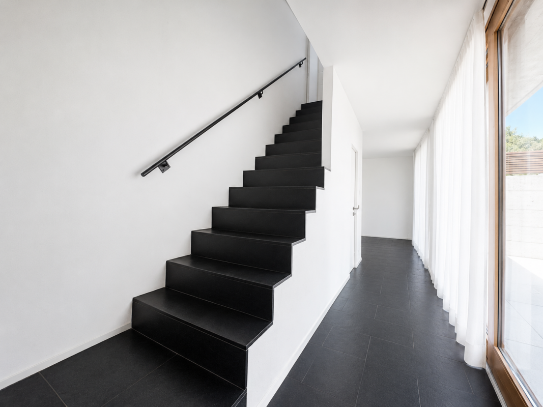 Moderner Flur mit schwarzer Treppe