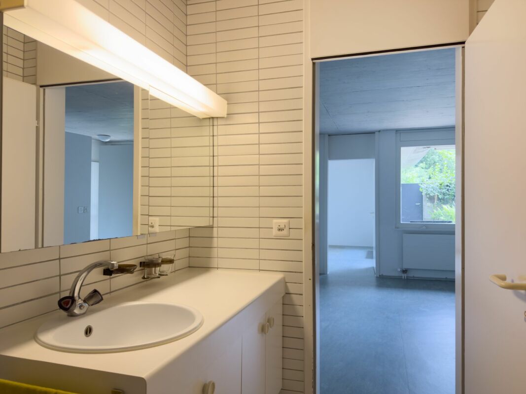 Badezimmer mit Waschbecken und Blick in angrenzende Räume