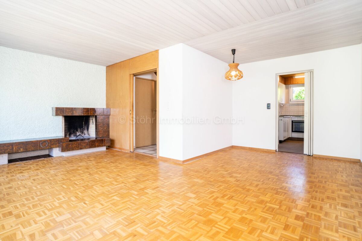 Wohnzimmer mit Kamin und Durchgang zur Küche