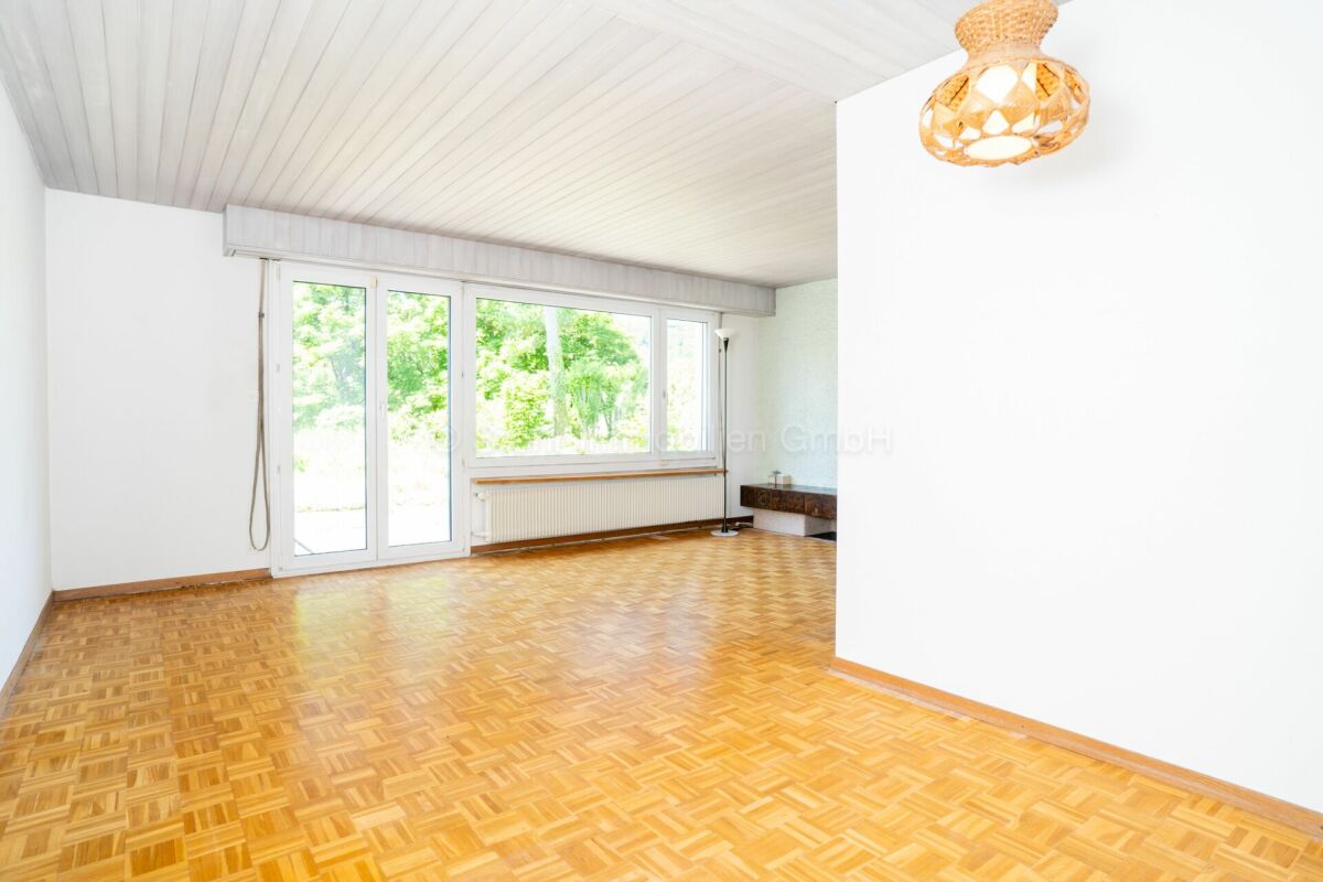 Heller Wohnraum mit Parkettboden und großen Fenstern