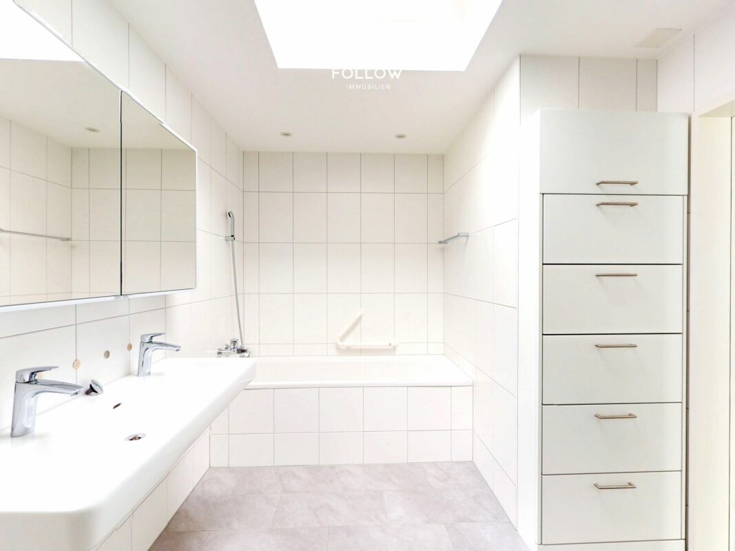 Helles, modernes Badezimmer mit Badewanne und Doppelwaschtisch