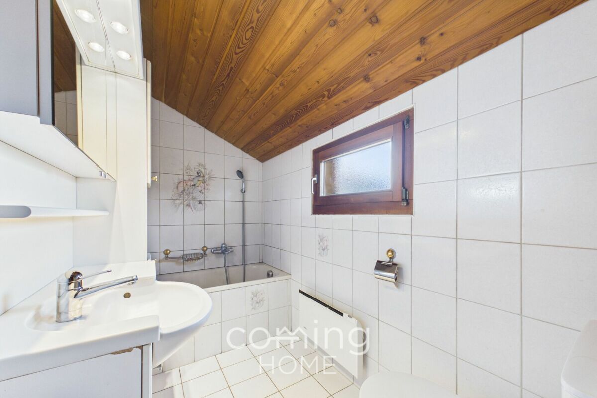 Badezimmer mit Holzdecke und Badewanne