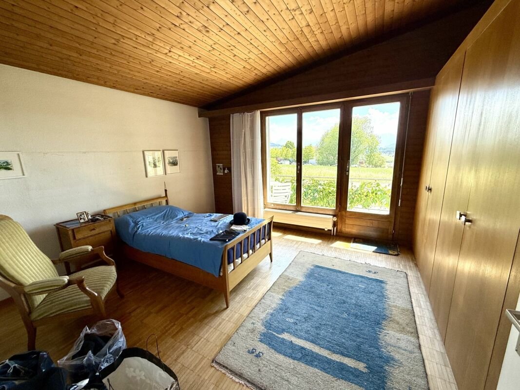 Schlafzimmer mit Holzdecke und Blick ins Grüne