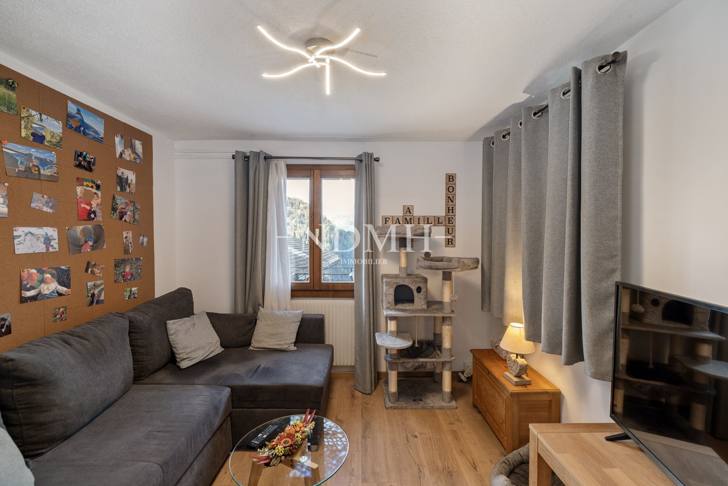 Gemütliches Wohnzimmer mit Sofa, Katzenbaum und Fensterblick