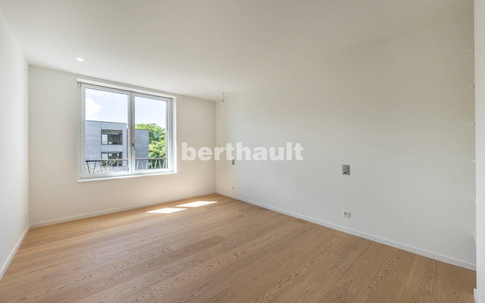 Helles leeres Zimmer mit Holzfußboden