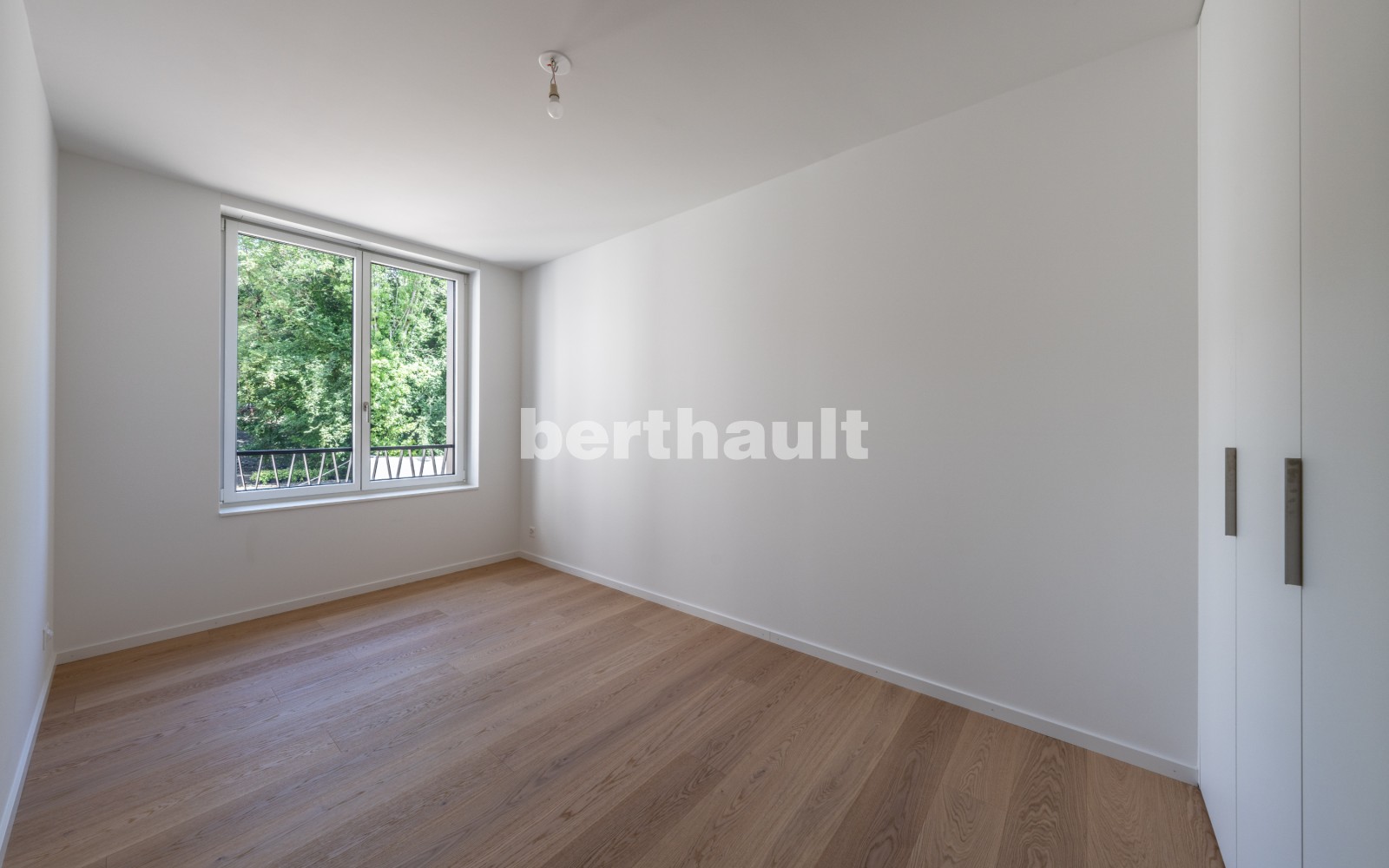 Leeres, modern renoviertes Schlafzimmer mit Parkettboden