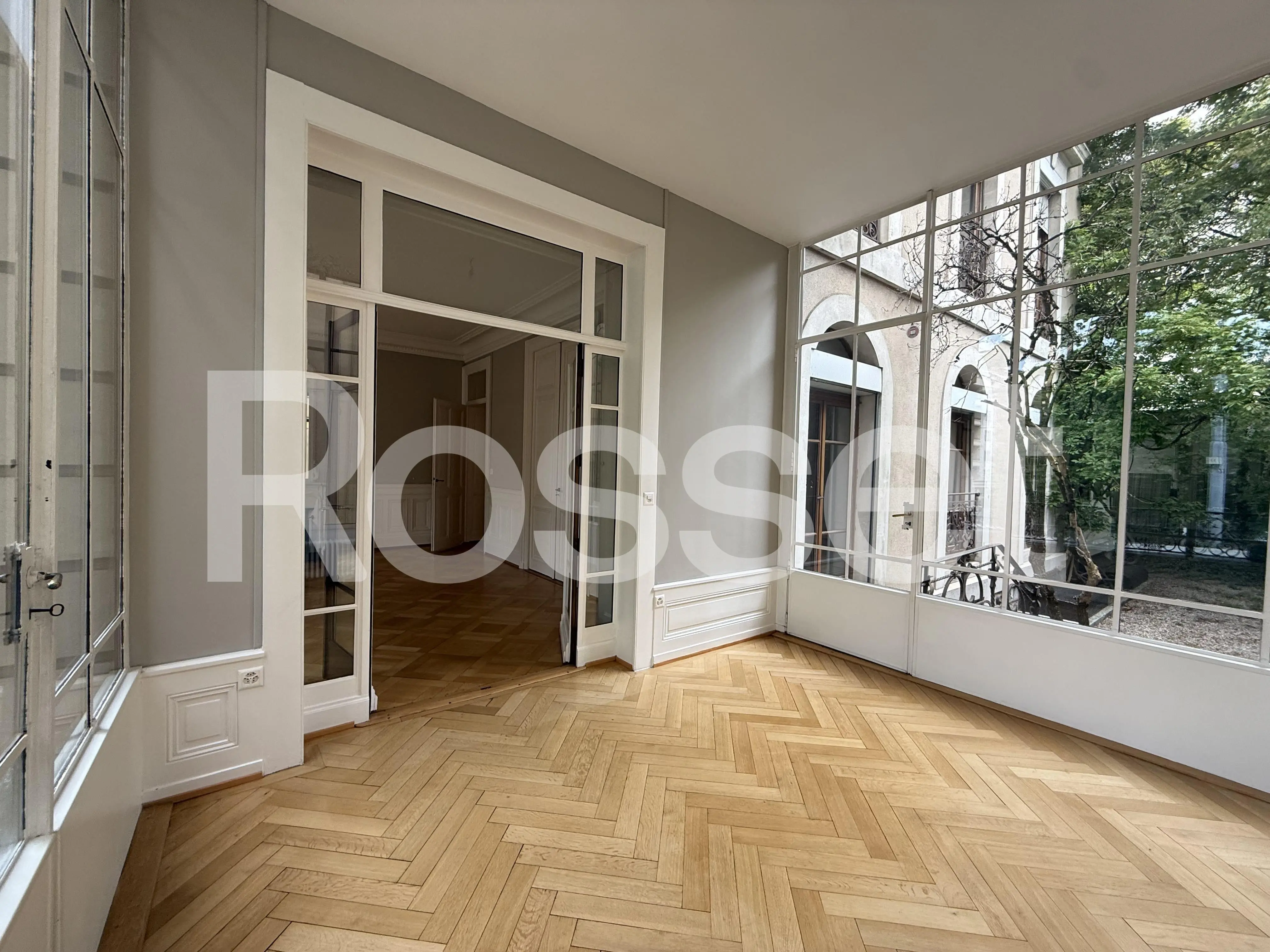 Verglaster Salon mit Fischgrätparkett