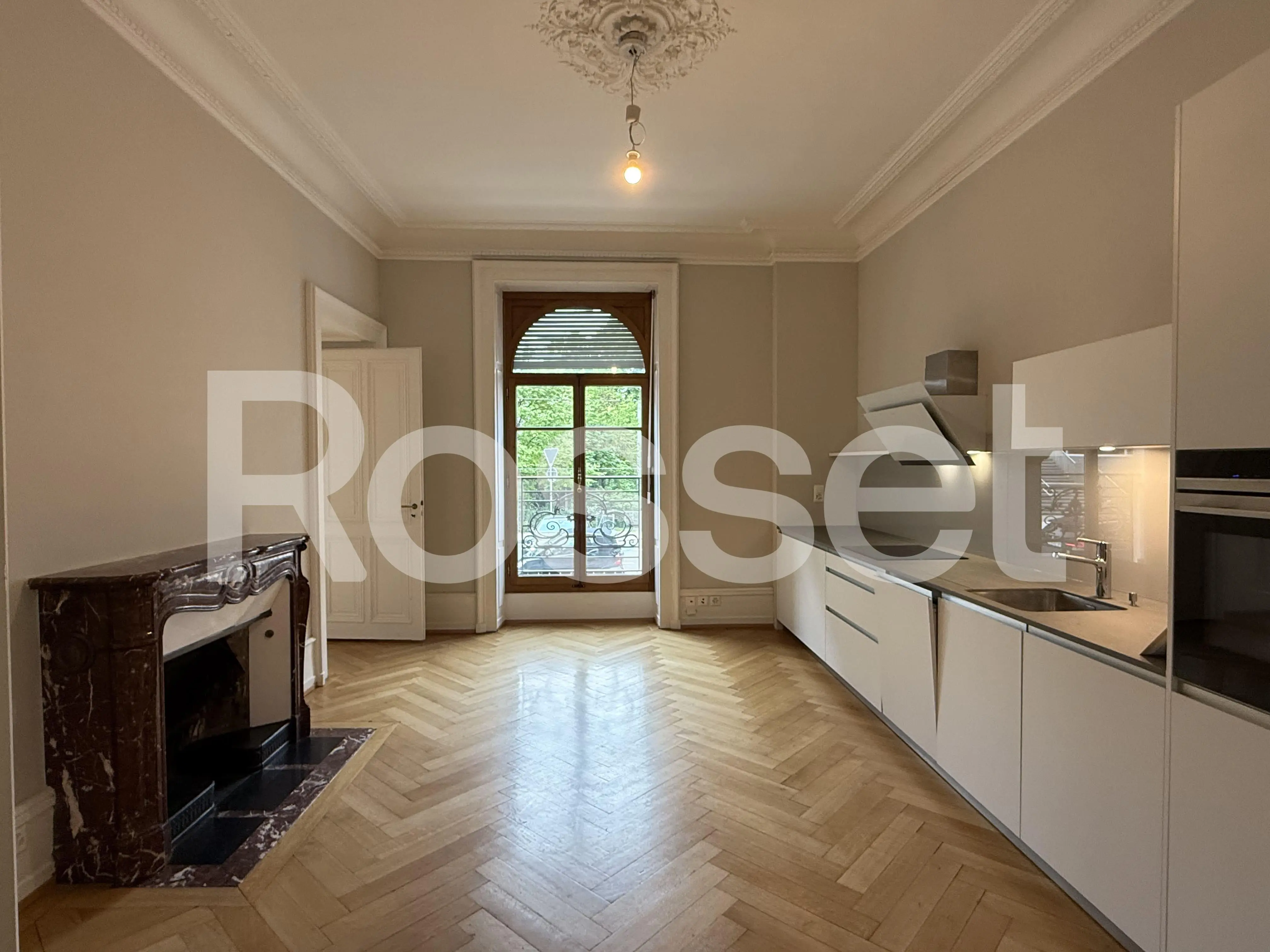 Elegante Küche mit historischem Kamin und Balkonblick