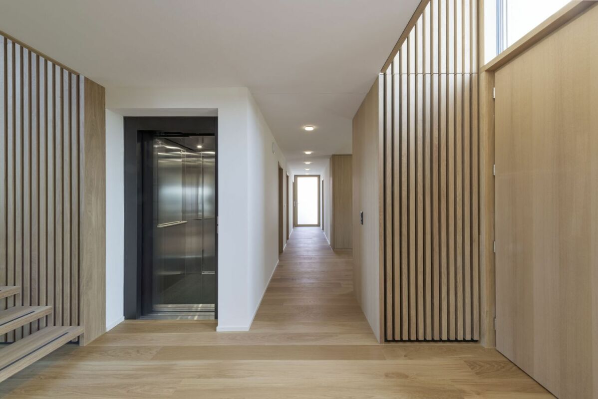 Moderner Flur mit Aufzug und Holzverkleidung