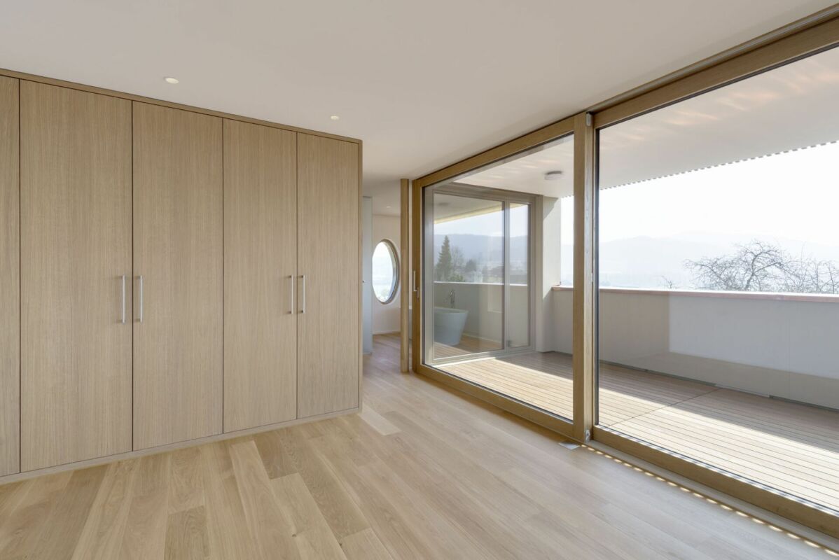 Heller Raum mit Einbauschränken und großer Glasfront zur Terrasse