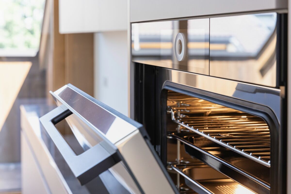 Moderne Einbauküche mit geöffnetem Backofen