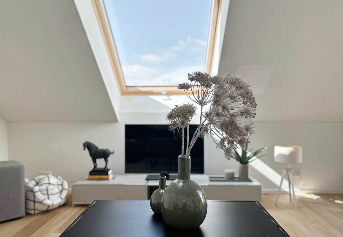 Dachgeschoss-Wohnraum mit Dachfenster und TV