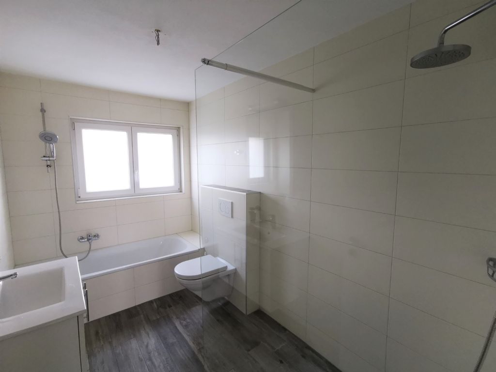 Modernes Badezimmer mit Badewanne und Glasabtrennung