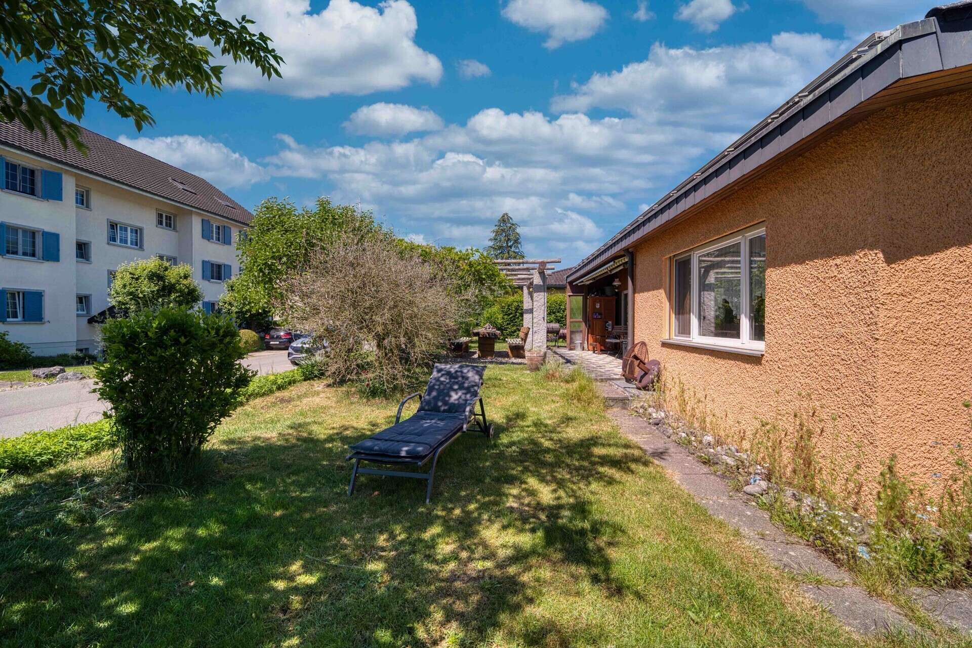 Garten mit Liege und Wohnhausansicht