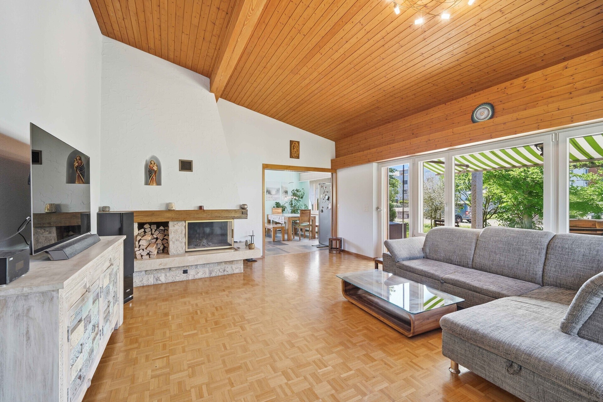 Wohnzimmer mit Holzdecke und Kamin